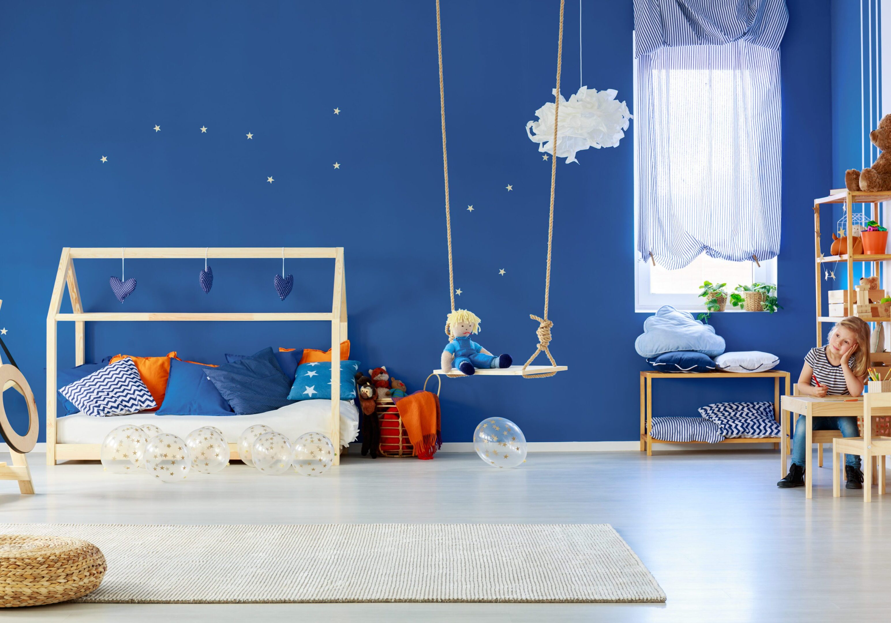 Young smiling girl drawing in colorful original decorated room